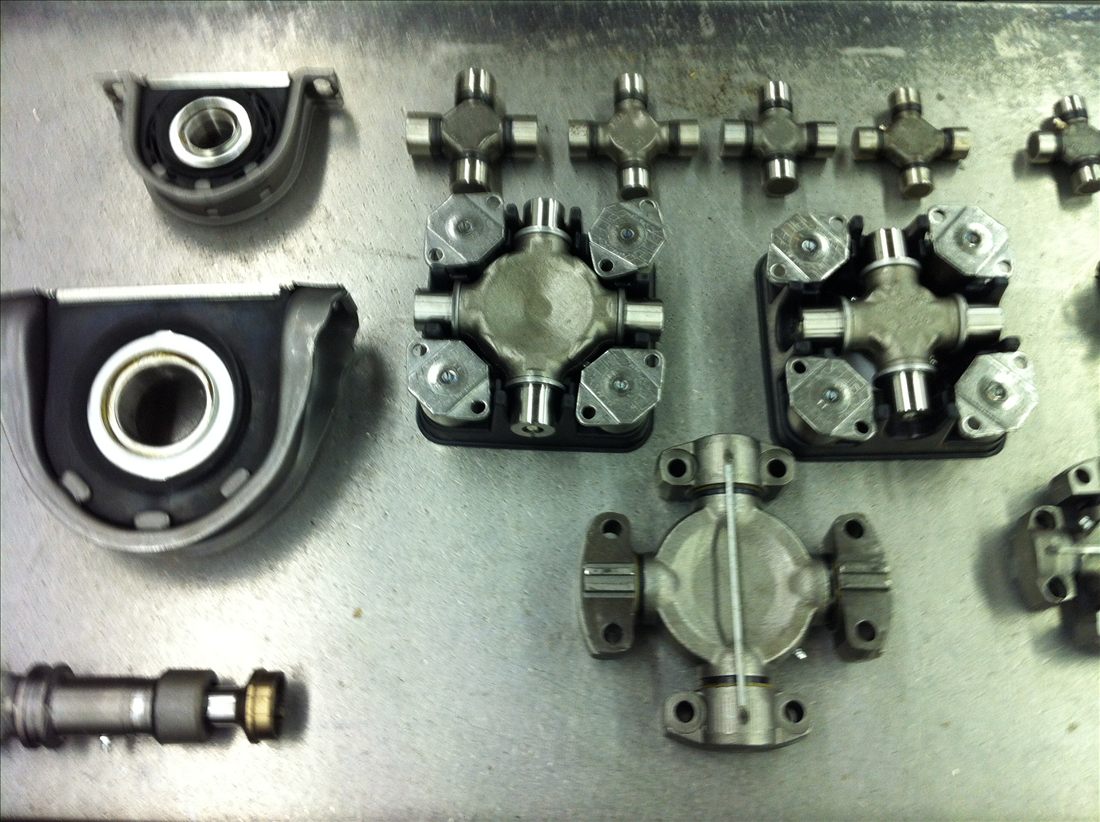 U-joint kits and center support bearings laid out on the bench
